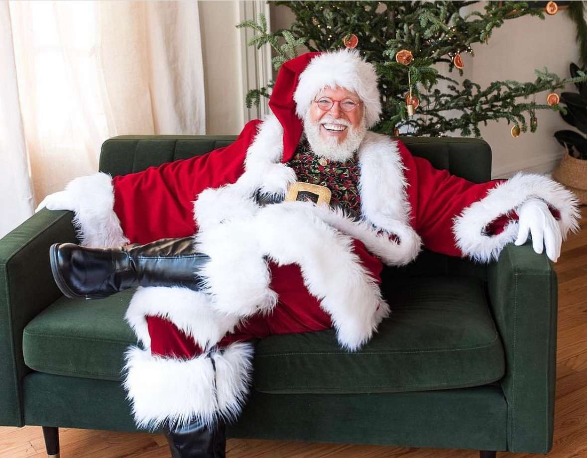 Santa CJ Kringle seated in an emerald green chair